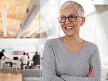 Woman smiling with short hair in grey long sleeve shirt