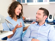 Patient and dental team member discussing details of root canal therapy