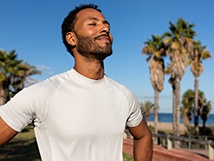 a man breathing in fresh air after going for a run