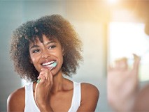 a person smiling and brushing their teeth