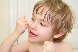 Boy flossing his teeth