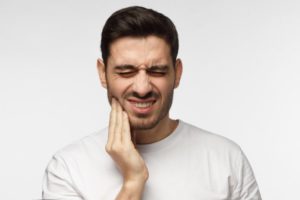 Man in white with tooth pain 