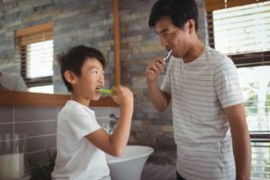 Man brushing his teeth looking in mirror