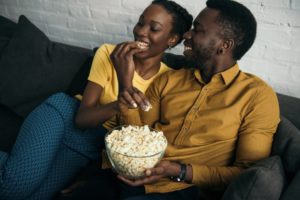 Couple eating popcorn on the couch together