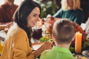 Woman and child at dinner table enjoying healthy thanksgiving 