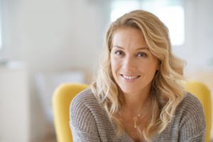 Older woman smiling after visiting her cosmetic dentist