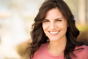 Woman smiling with healthy gums while sitting